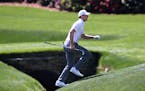 Jordan Spieth runs across the tributary to Rae's Creek to the 13th green during his practice round for the Masters at Augusta National Golf Club.
