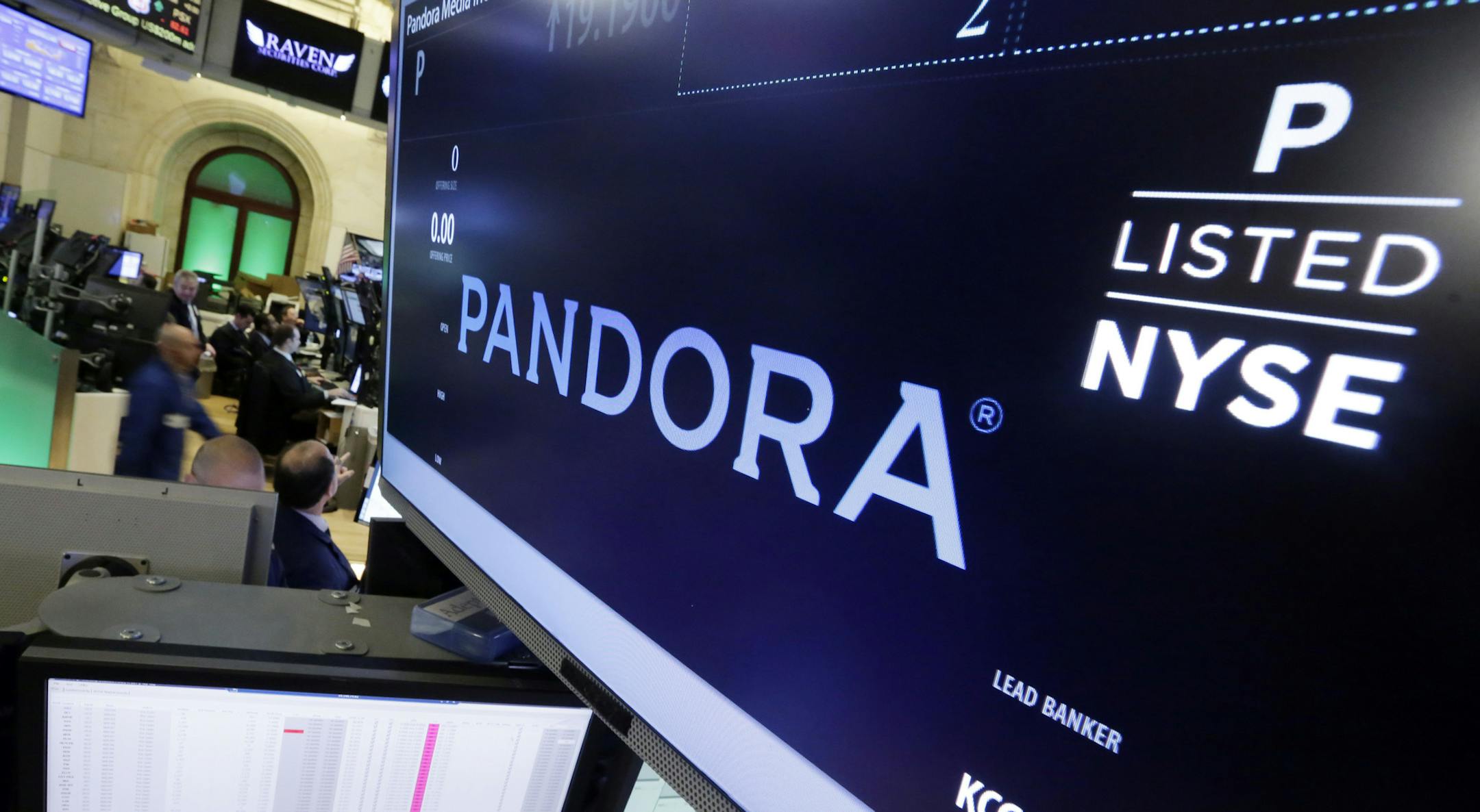 FILE - In this Oct. 23, 2015 file photo, Pandora is displayed above a post where it trades on the floor of the New York Stock Exchange. Pandora's stock is climbing Friday, Jan. 13, 2017, after the online radio company provided a stronger fourth-quarter revenue outlook and announced plans to cut approximately 7 percent of its workforce. Pandora said late Thursday that the job cuts, which would exclude Ticketfly, are being done to help trim overall operating costs.(AP Photo/Richard Drew, File)