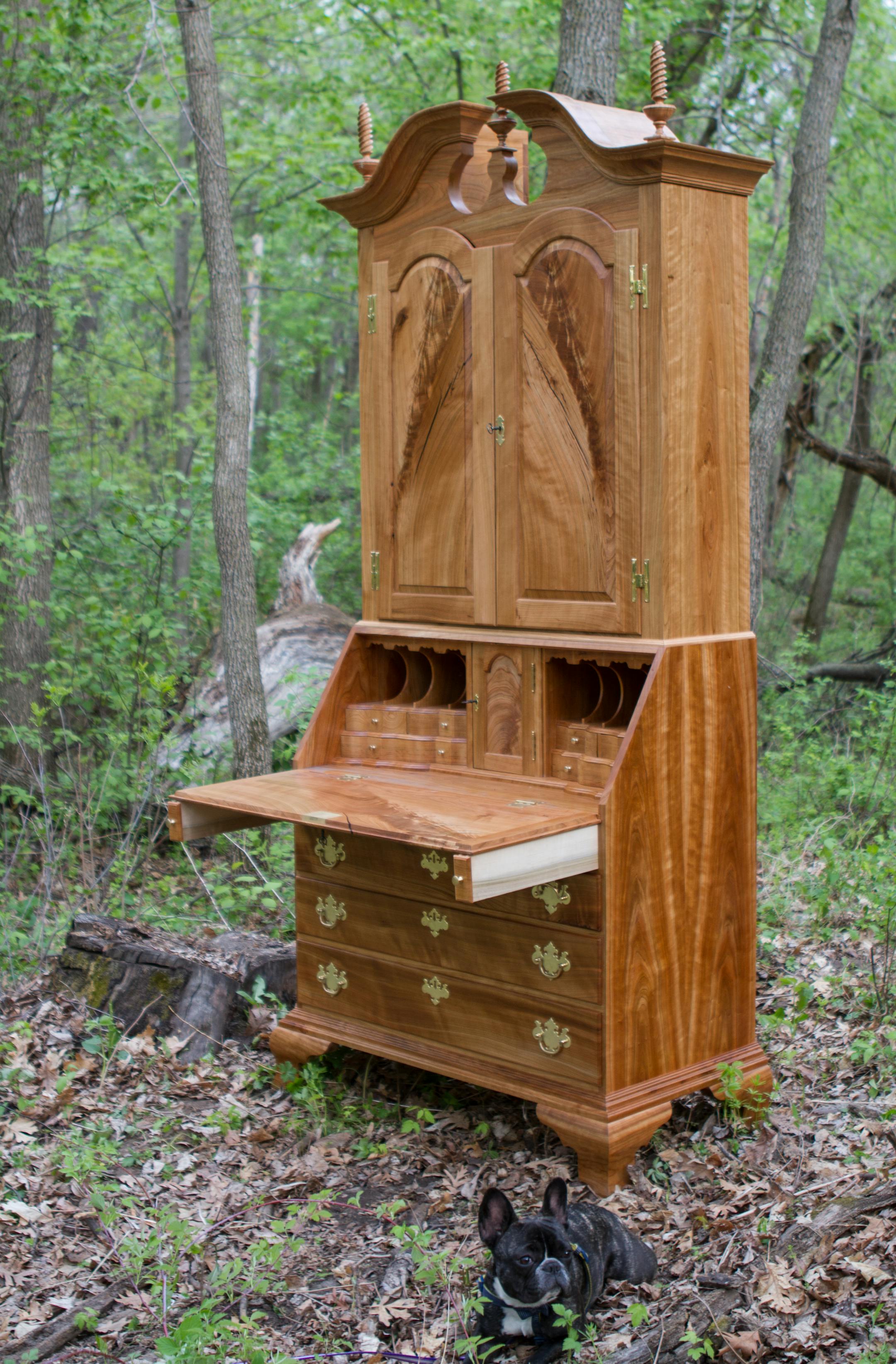 A cherry secretary desk, built by Matt Cremona, standing in the Oak Grove location where the wood originated.