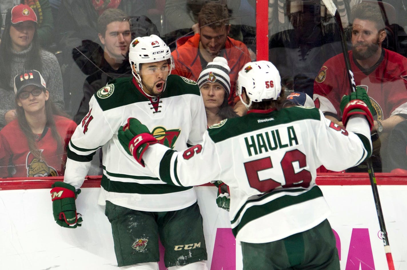 Minnesota Wild defenceman Matt Dumba, left, celebrates his game-winning goal with teammate center Erik Haula during overtime in an NHL hockey game Sunday, Nov. 13, 2016, in Ottawa, Ontario. (Adrian Wyld/The Canadian Press via AP)