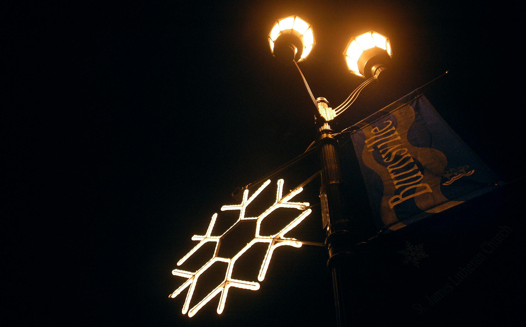 Heather Charles/ Star Tribune Burnsville, MN: 11/25/04: A large snowflake light hangs from a light post along Nicollet Avenue in Burnsville. Holiday lights run all along Nicollet Avenue in the Heart of the City District as well as Nicollet Commons Park in Burnsville. The City of Burnsville held a holiday lighting ceremony Wednesday, November 24. GENERAL INFORMATION: Feature on Nicolett Park in Burnsville Christmas Lights. ORG XMIT: MIN2012110914225222