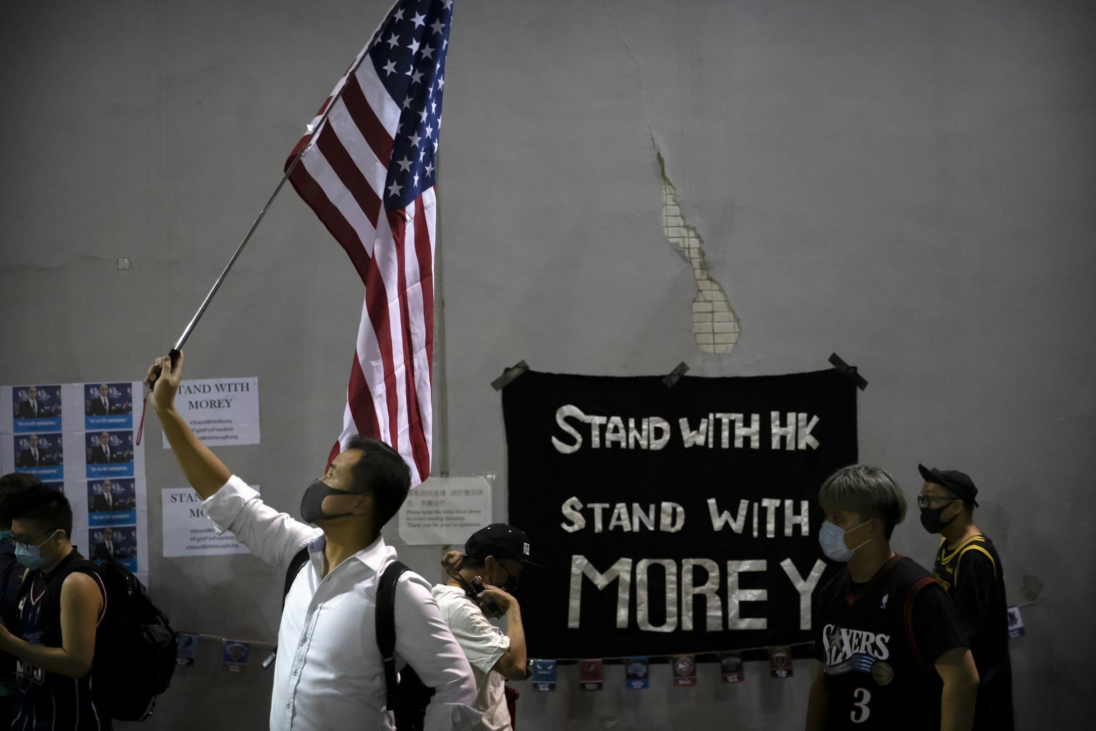 A demonstrator holds a U.S. flag during a rally at the Southorn Playground in Hong Kong, Tuesday, Oct. 15, 2019. Protesters in Hong Kong have thrown basketballs at a photo of LeBron James and chanted their anger about comments the Los Angeles Lakers star made about free speech during a rally in support of NBA commissioner Adam Silver and Houston Rockets general manager Daryl Morey, whose tweet in support of the Hong Kong protests touched off a firestorm of controversy in China. (AP Photo/Mark Sc