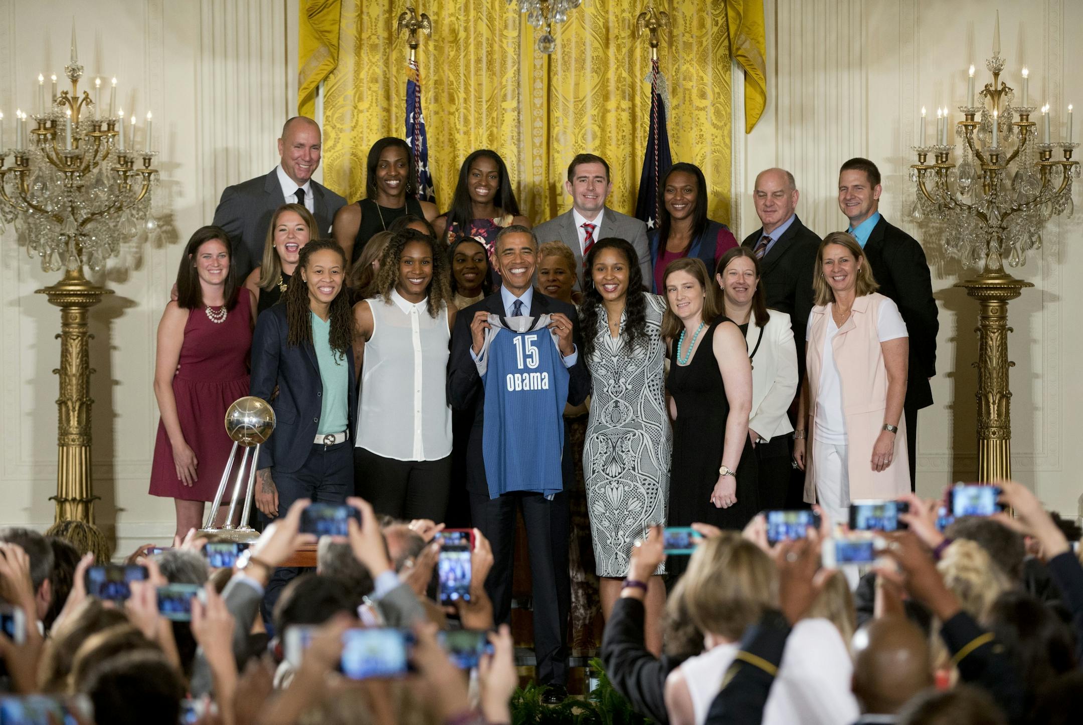 President Barack Obama, center, holds up a team jersey for a group photo in the East Room of the White House in Washington, Monday, June 27, 2016, during a ceremony where he honored the 2015 WNBA basketball Champion Minnesota Lynx.
