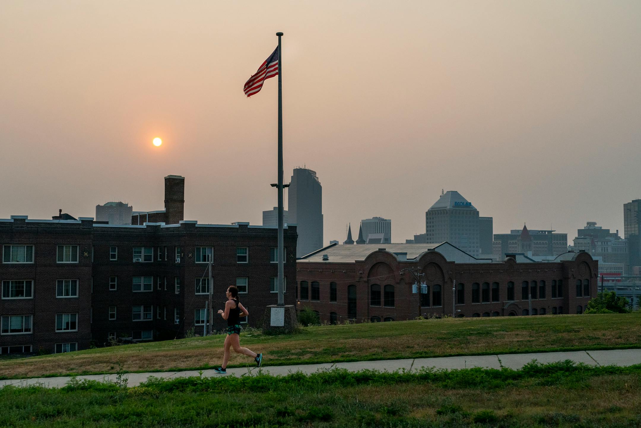A person runs down Summit Avenue during a smoke filled sunrise on Saturday, July 31, 2021, in St. Paul. Canadian wildfires continue to effect the air quality in the Twin Cities. ] ANTRANIK TAVITIAN • anto.tavitian@startribune.com