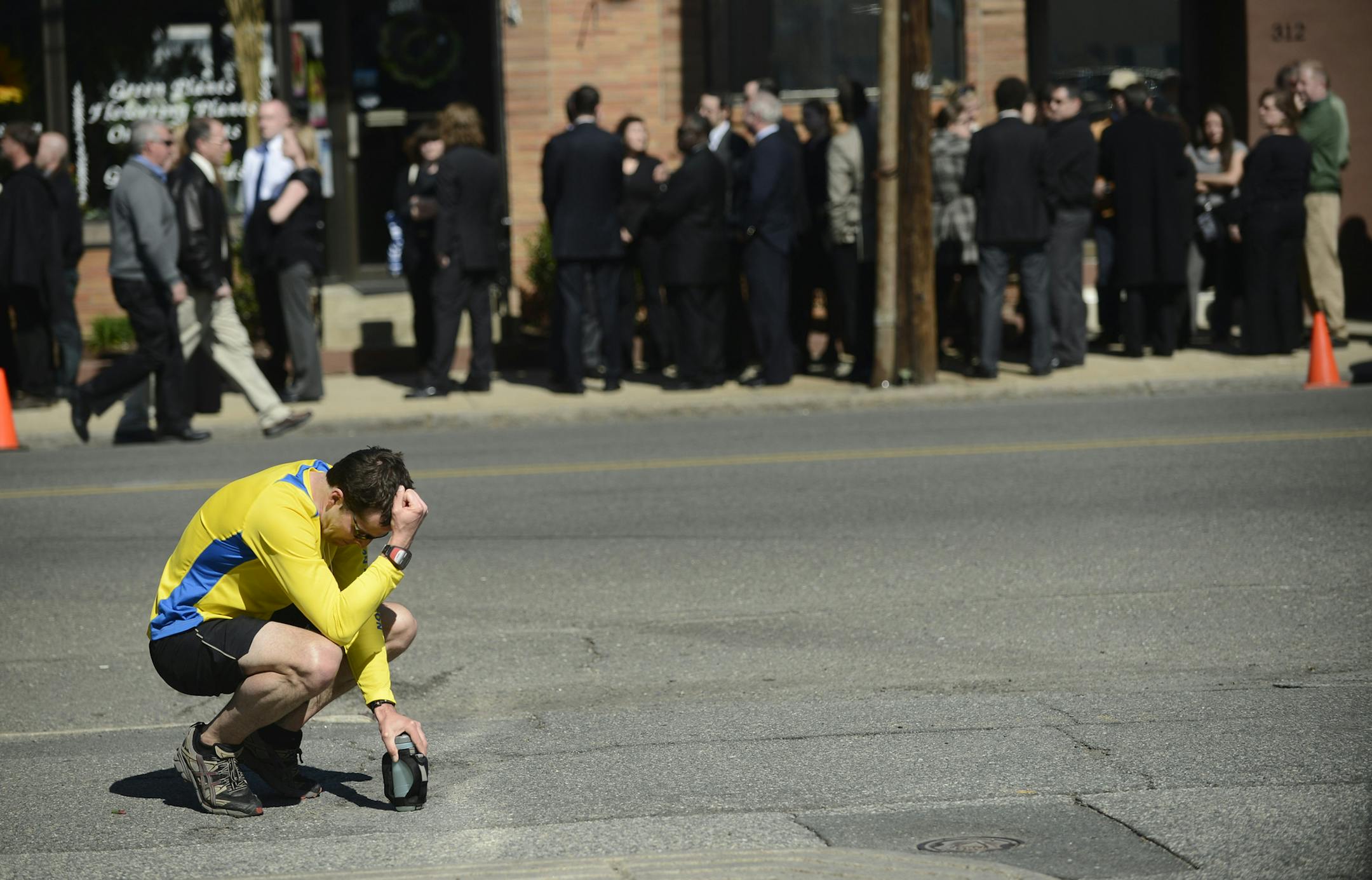 A runner pauses to reflect as friends and family of Krystle Campbell, one of the three people killed in the Boston bombing, gather for her wake in Medford, Mass., April 21, 2013. With the surviving suspect of the bombing in the hospital &#x2014; a breathing tube down his throat and unable to speak &#x2014; several lawmakers said Sunday that he should be tried in federal court as a civilian, a move that would allow prosecutors to seek the death penalty. (Gretchen Ertl/The New York Times)