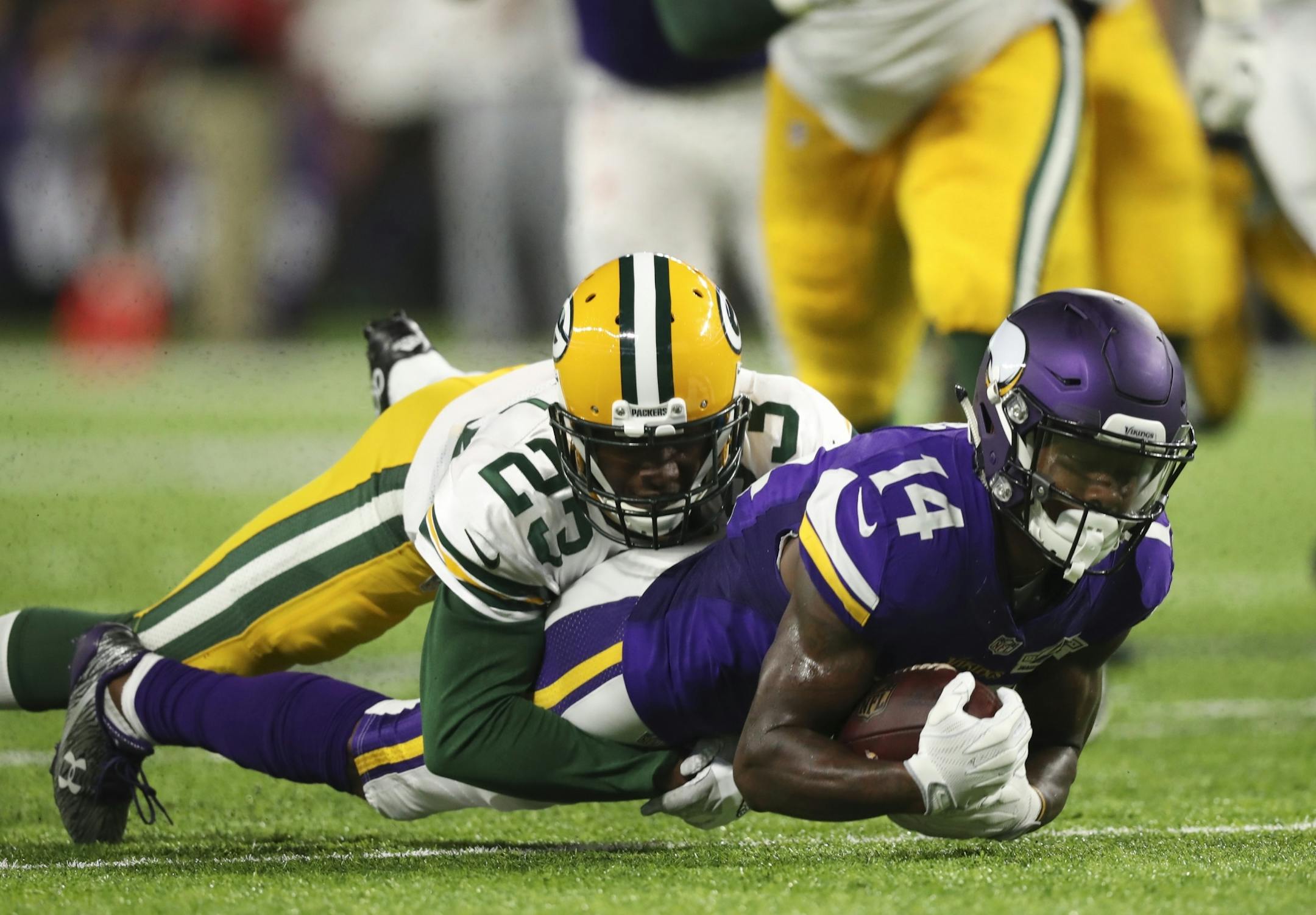 Vikings wide receiver Stefon Diggs (14) was tackled by Green Bay Packers cornerback Damarious Randall (23) after a second quarter pass reception.