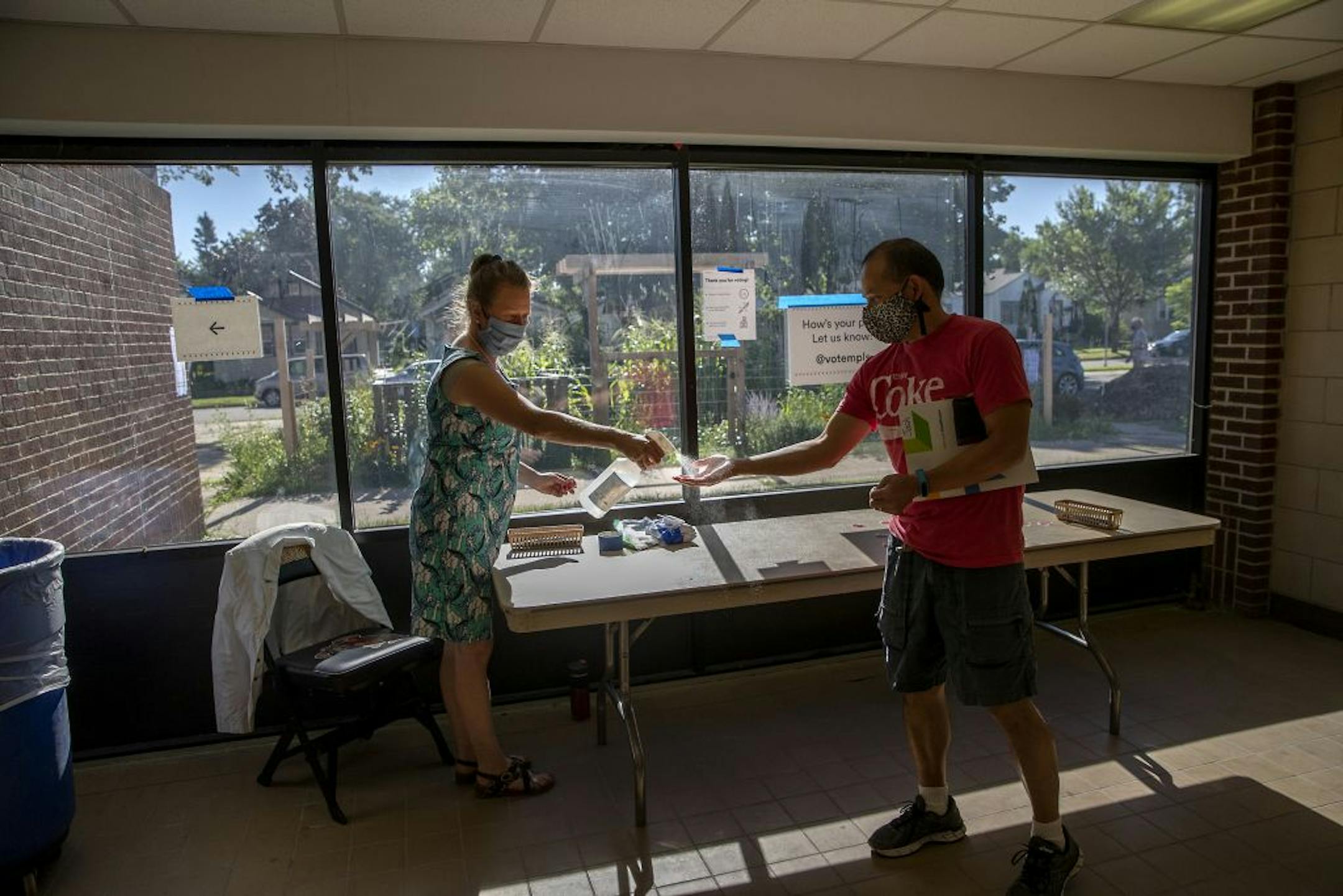 Election volunteer Linda Kunert, cq, sprayed voters with hand sanitizer after they voted at the Roosevelt High School polling location, Tuesday, August 11, 2020 in Minneapolis, MN.