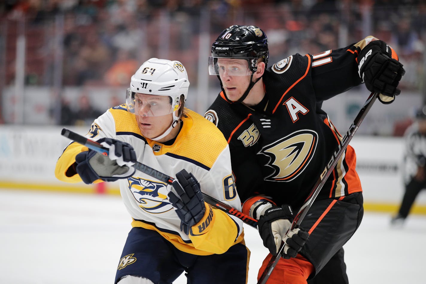 Nashville Predators' Mikael Granlund, left, of Finland, and Anaheim Ducks' Corey Perry chase the puck during the first period of an NHL hockey game, Tuesday, March 12, 2019, in Anaheim, Calif. (AP Photo/Jae C. Hong)