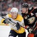 Nashville Predators' Mikael Granlund, left, of Finland, and Anaheim Ducks' Corey Perry chase the puck during the first period of an NHL hockey game, T