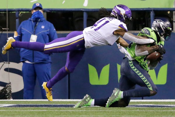 The Seattle Seahawks' DK Metcalf caught the ball in the end zone for the winning touchdown as Minnesota Vikings' Anthony Harris defends.