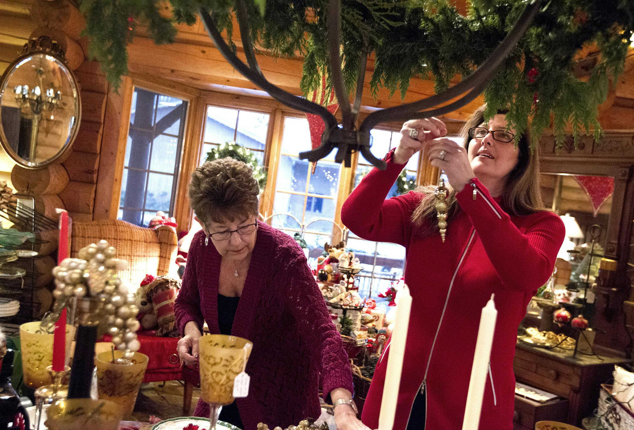 Owner and founder Claudia Lacy, right, and volunteer Denise Perrin arrange a home decor display at Langdon Inc. in Mound.
