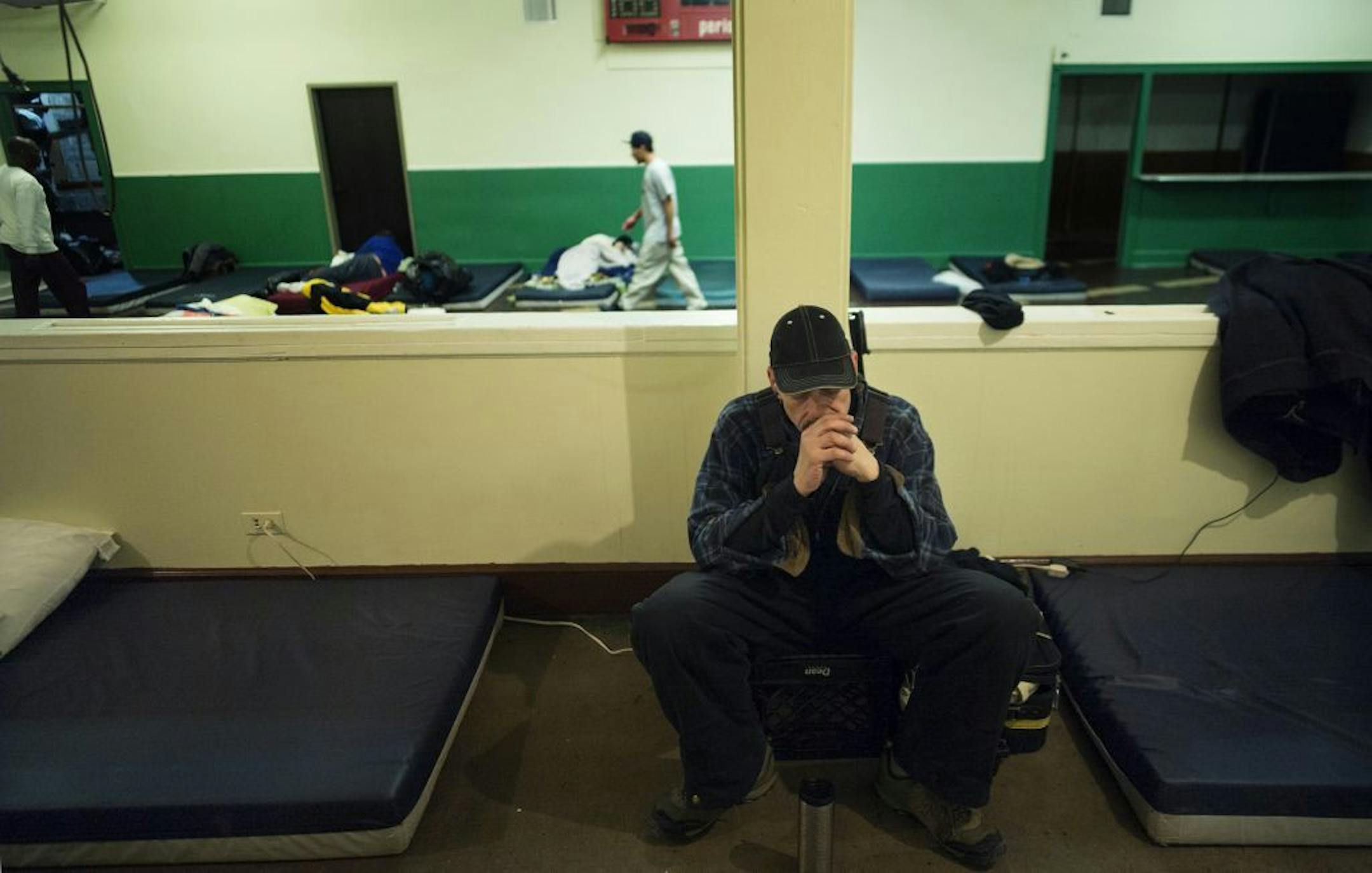 At the shelter housed in the basement of Simpson United Methodist Church, David Thompson listened to some music next to the mattress where he would sleep on a night where the wind chill was expected to dip to 20 below zero.