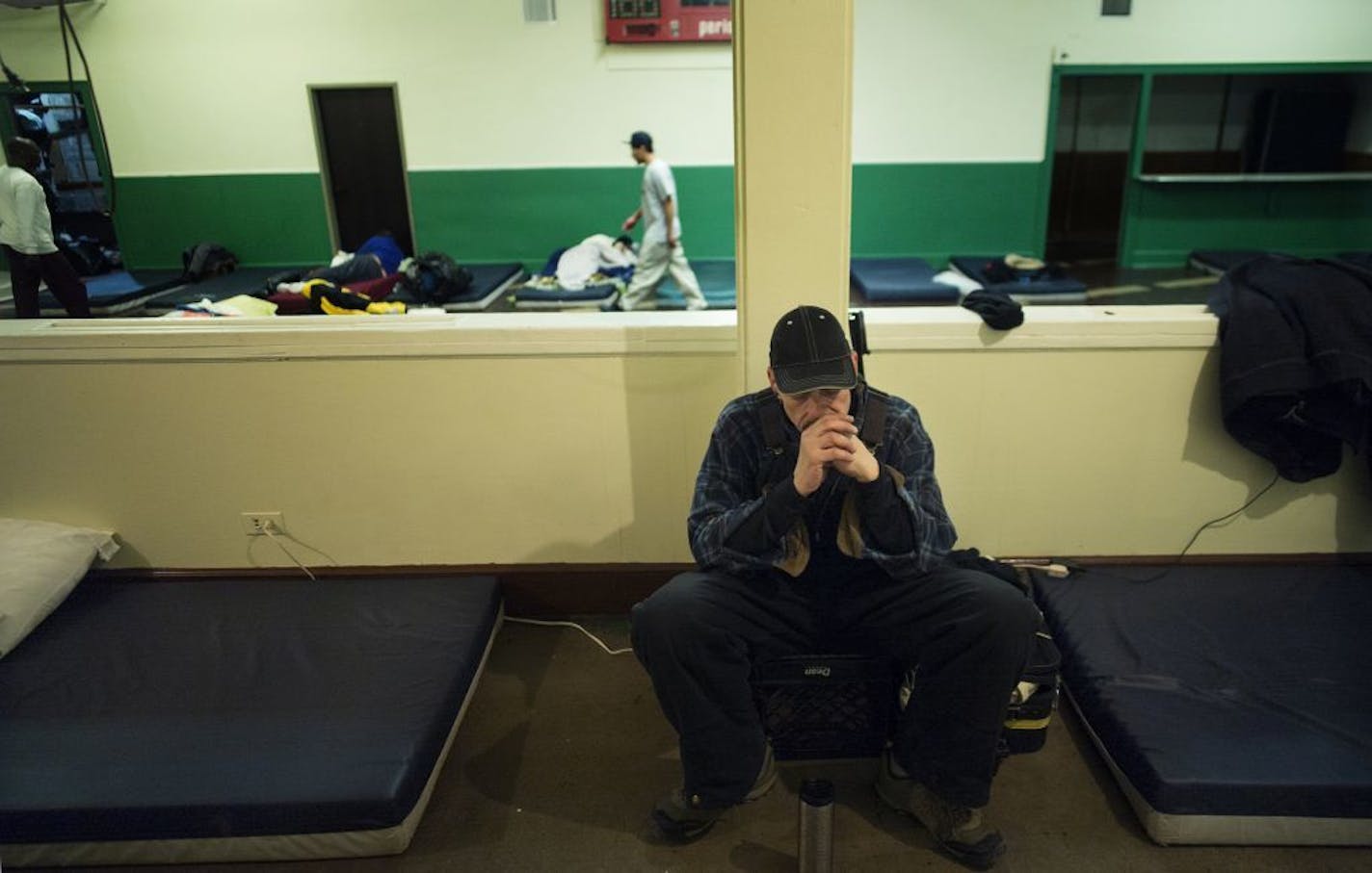 At the shelter housed in the basement of Simpson United Methodist Church, David Thompson listened to some music next to the mattress where he would sleep on a night where the wind chill was expected to dip to 20 below zero.