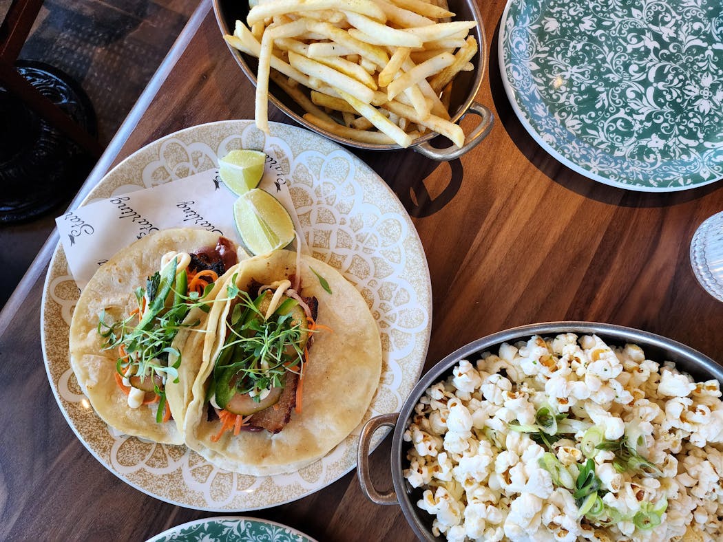 Pork belly tacos, curry fries and furikake popcorn from the eclectic menu at Starling in Edina.