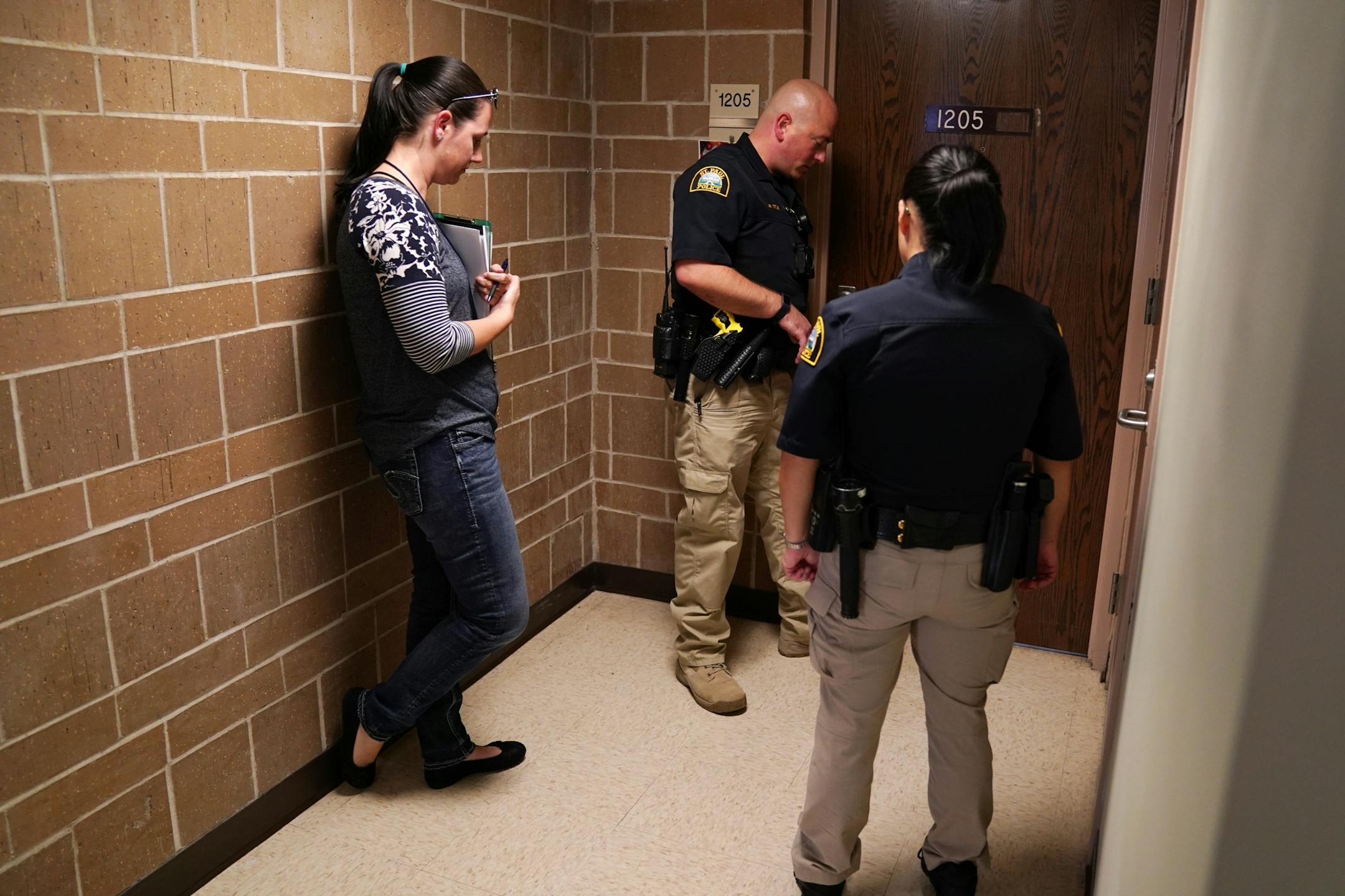 Licensed clinical social worker Kara Haroldson stood with officers Justin Tiffany and Lori Goulet as they checked the well being of a woman they had previous contact with.