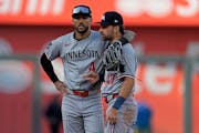 Twins infielders Carlos Correa and Edouard Julien talk during Saturday's game at Kansas City. While Correa is one of baseball's highest-paid players, 
