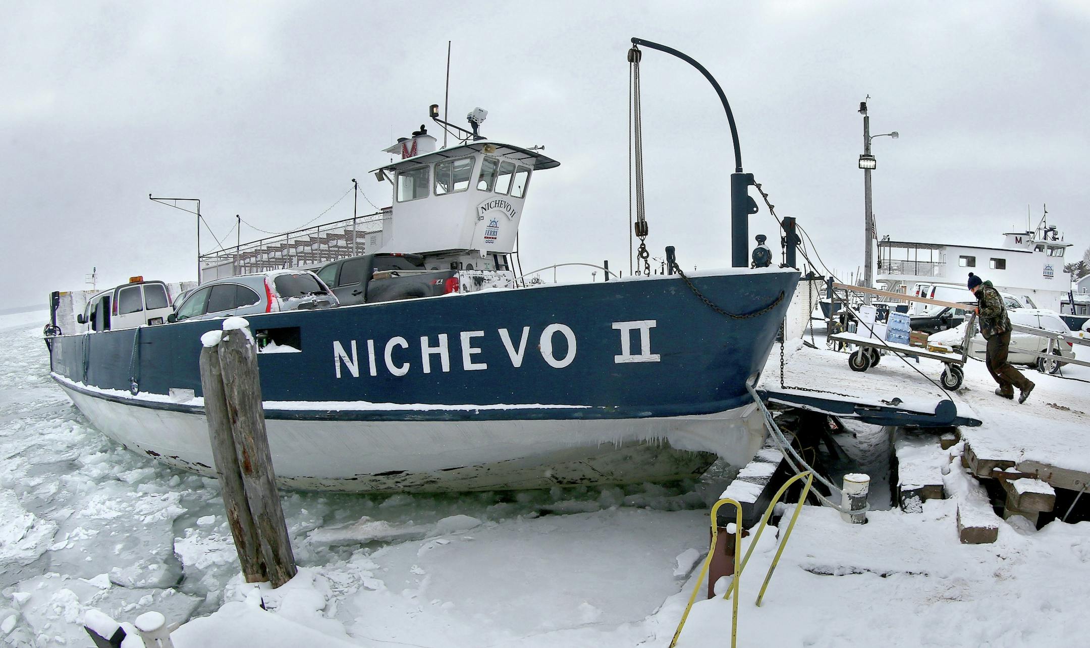 t1.5.18 Bob King -- 010618.N.DNT.FERRYc4 -- Sam Carrier of Washburn, the Nichevo II crew, carts water, berries and lumber on board the Nichevo II in Bayfield shortly before it departs for Madeline Island Friday morning. Bob King / rking@duluthnews.com