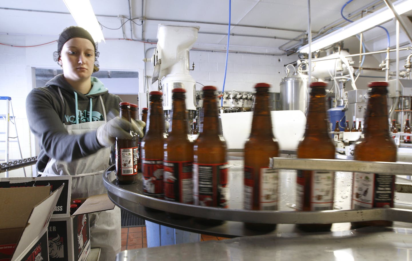 Nikki Hanson pulls bottles of Cock & Bull Ginger Beer off the line at the Spring Grove Soda Pop Company in Spring Grove, MN Friday January 9, 2015. The soda pop company bottles 10 flavors of it's own pop in addition to the ginger beer. (AP Photo/Ken Klotzbach, Post-Bulletin)