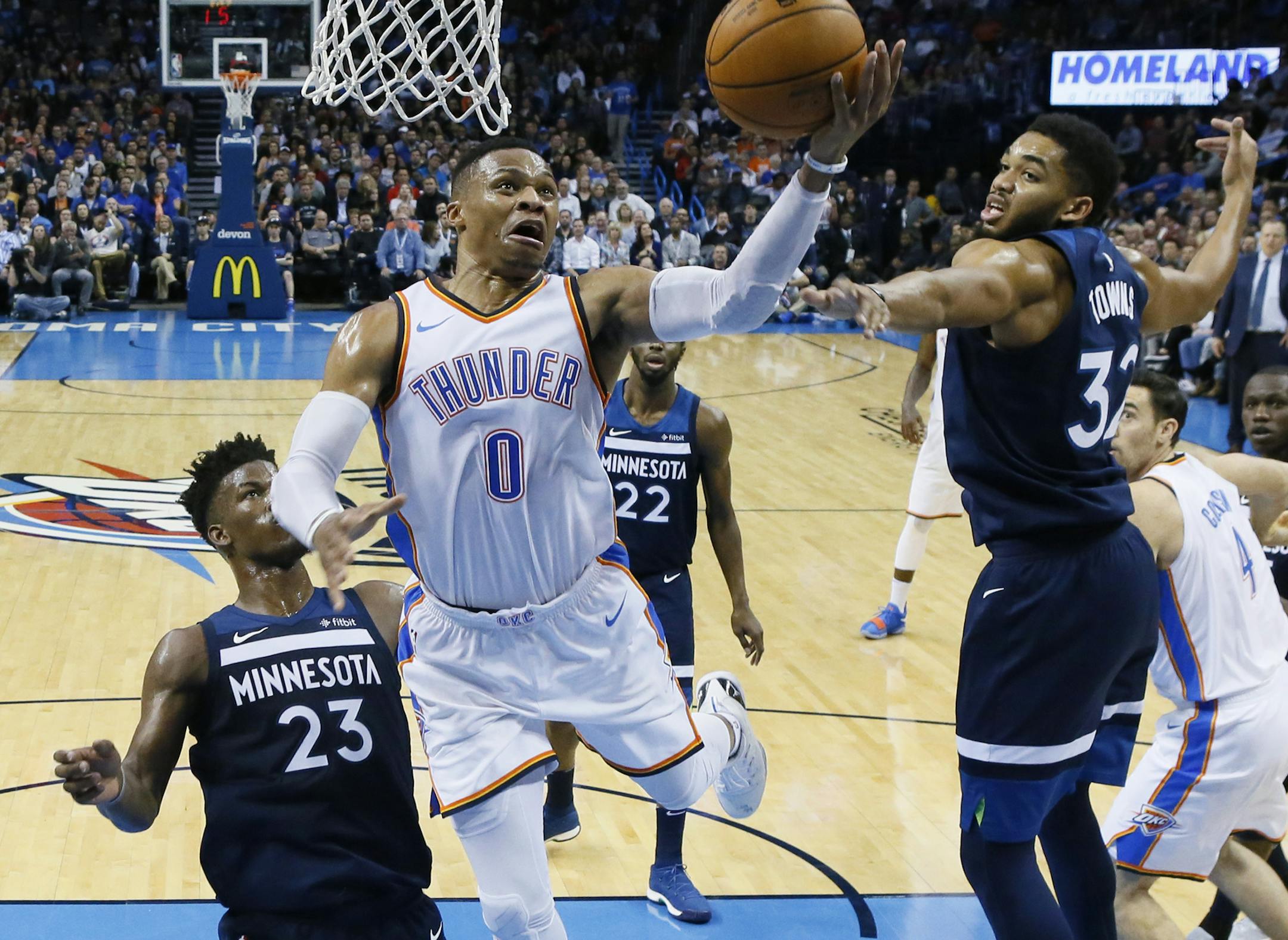 Oklahoma City Thunder guard Russell Westbrook (0) shoots between Minnesota Timberwolves guard Jimmy Butler (23) and center Karl-Anthony Towns during the second quarter of an NBA basketball game in Oklahoma City, Friday, Dec. 1, 2017. (AP Photo/Sue Ogrocki)