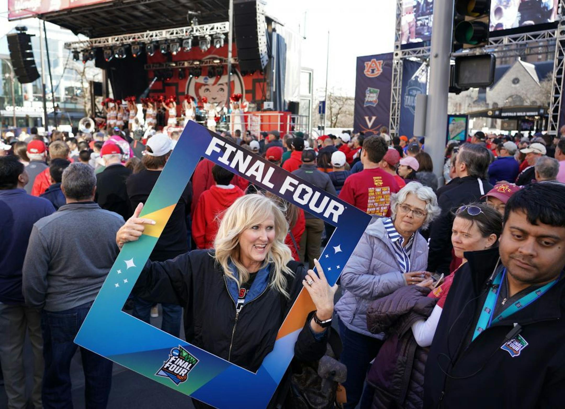 Texas Tech fan T. Mann of Lubbock, Texas, had her "Guns Up" and face framed for a Final Four portrait during a pep rally on the Nicollet Mall before the championship game Monday night.