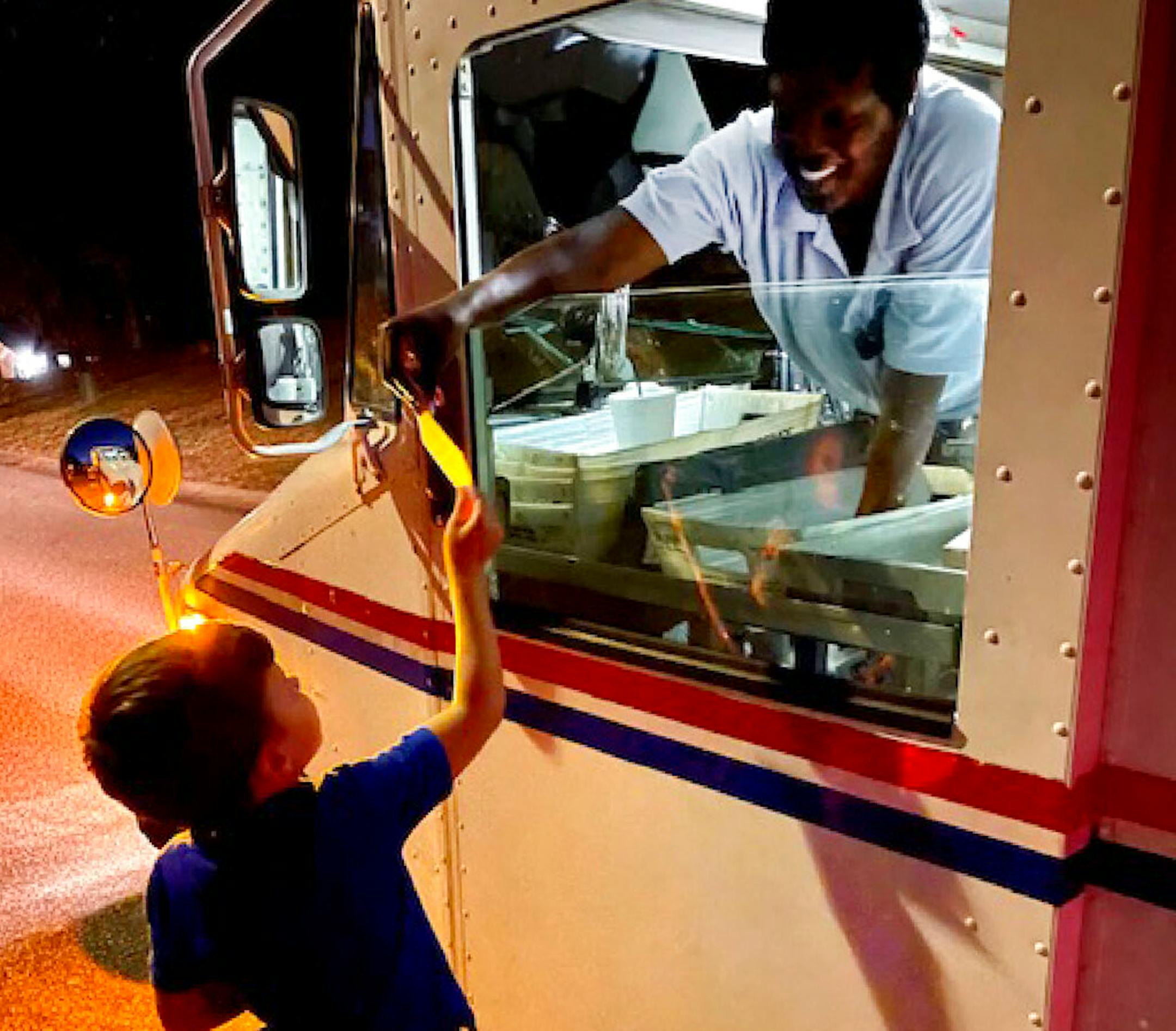Chip Matthews, 6, hands postal worker, Tawanna Purter, a thank you card.