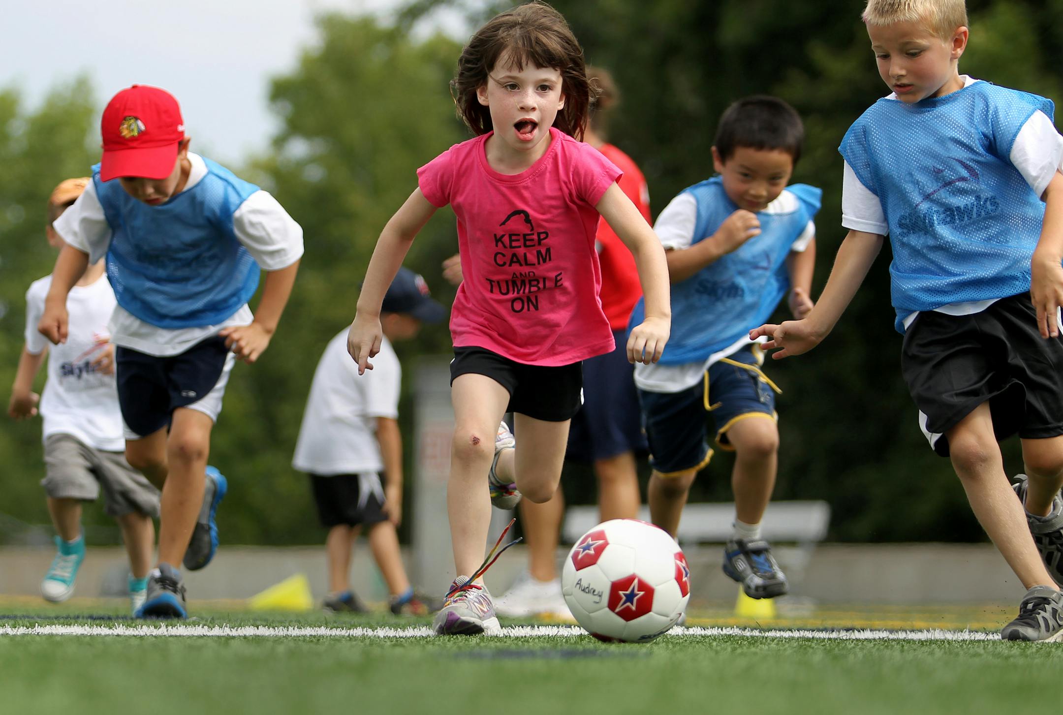 Madison Dovenberg, center, 6, of Maple Grove leads the charge on a soccer ball at the Skyhawks Sports Academy "Mini-Hawks" Camp at the Plymouth Creek Center in Plymouth, Minn., on Thursday, August 15, 2013. National public health advocates celebrated a first-ever drop in child obesity last week. ] (ANNA REED/STAR TRIBUNE) anna.reed@startribune.com (cq)