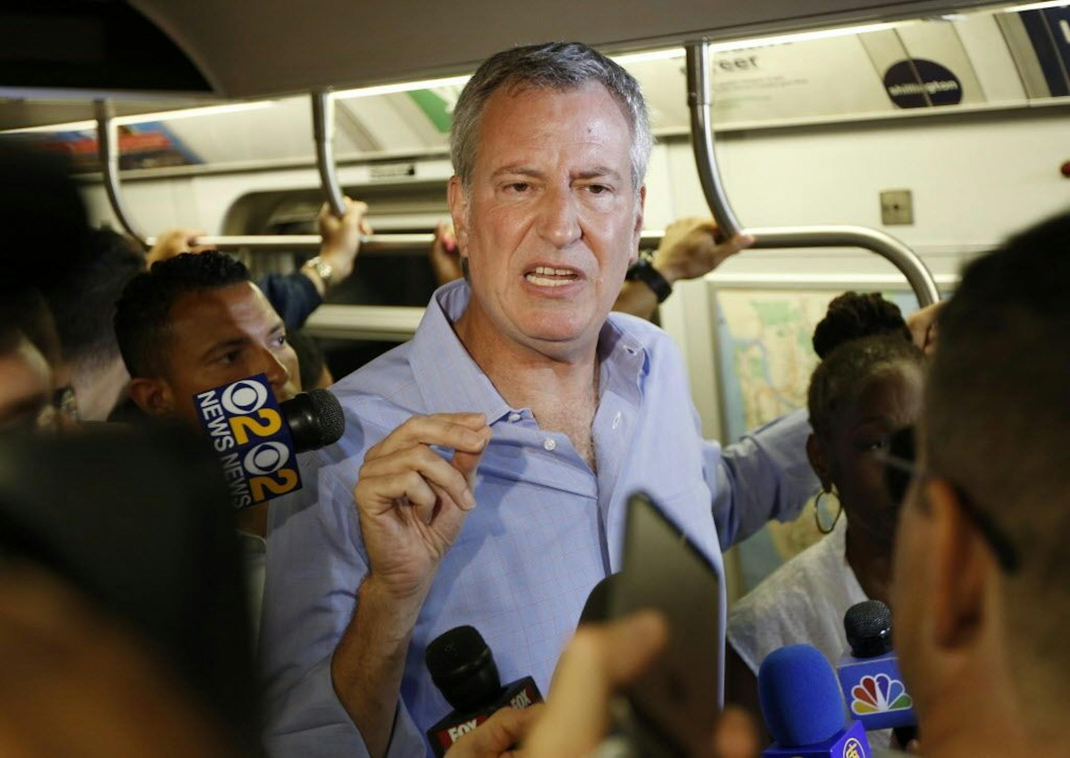 FILE - In this July 23, 2017 file photo, New York Mayor Bill de Blasio talks to reporters on the subway in New York. De Blasio wants to tax the wealthiest 1 percent of New Yorkers to fund repairs and improvements to the beleaguered subway system. The proposal comes as the mayor and Gov. Andrew Cuomo continue to squabble over who is responsible for paying for repairs to the nation's largest system.