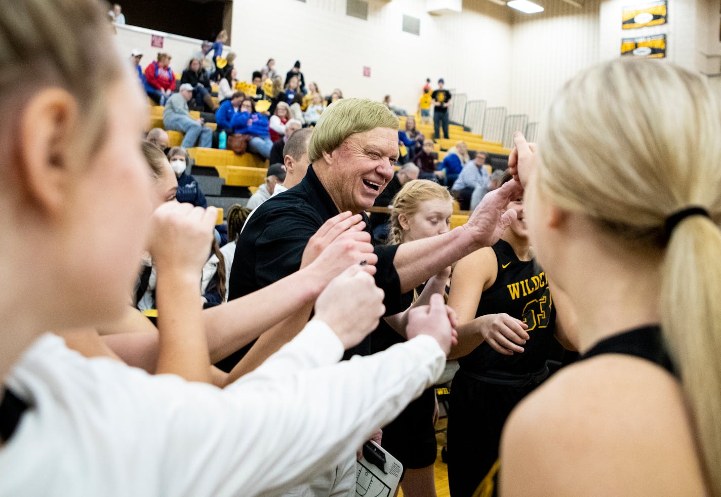 New London-Spicer head coach Mike Dreier, center, cracks a smile during the final timeout before his team defeated Watertown-Mayer on Friday, Jan. 28, 2022. The Wildcats won 60-36 to give Dreier his 1,000th victory.