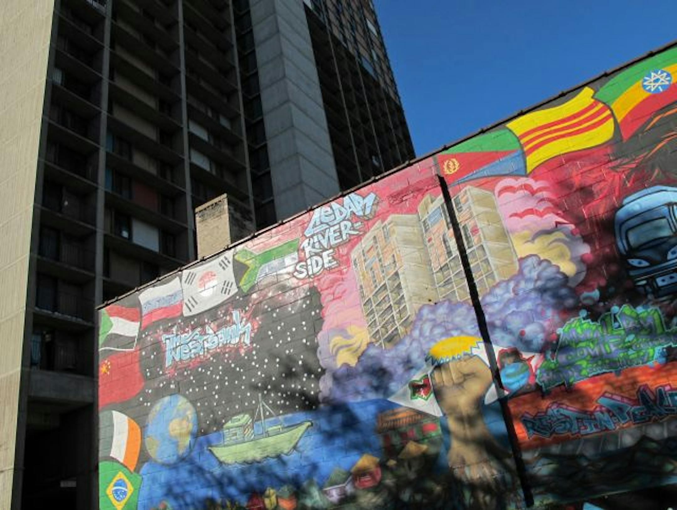 -arch1114,- Cedar Square West by Ralph Rapson has been designated 'historic' - the Cedar Riverside buildings are included in this painted mural on on the wall of the Cedar theater, in front of the complex, depicting the ethic diversity of the neighborhood.