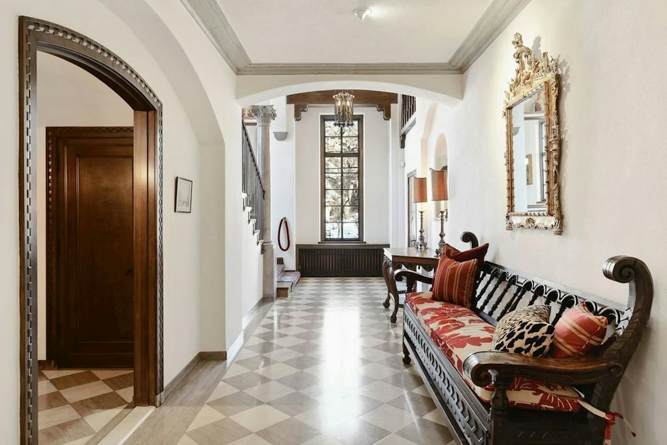 A tall window illuminates the main floor's formal entryway and staircase.
