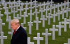 President Donald Trump is backdropped by headstones as he prepares to speak during an American Commemoration Ceremony, Sunday Nov. 11, 2018, at Suresn