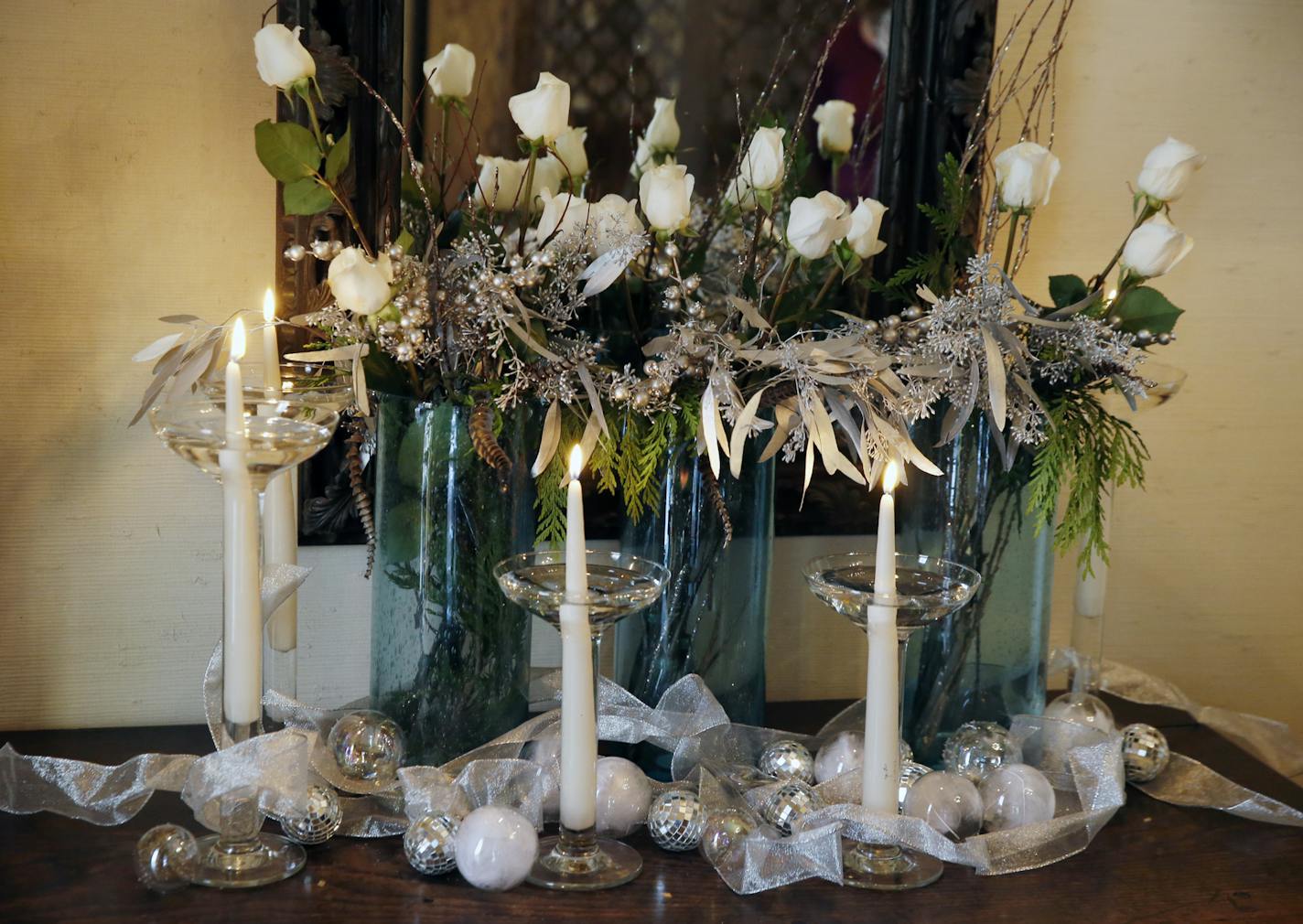 Designer Talla Skogmo has two holiday centerpieces.This one makes use of roses, balls. candles, silver painted branches with leaves, and a fresh cypress branch.]Richard Tsong-Taatarii/rtsong- taatarii@startribune.com