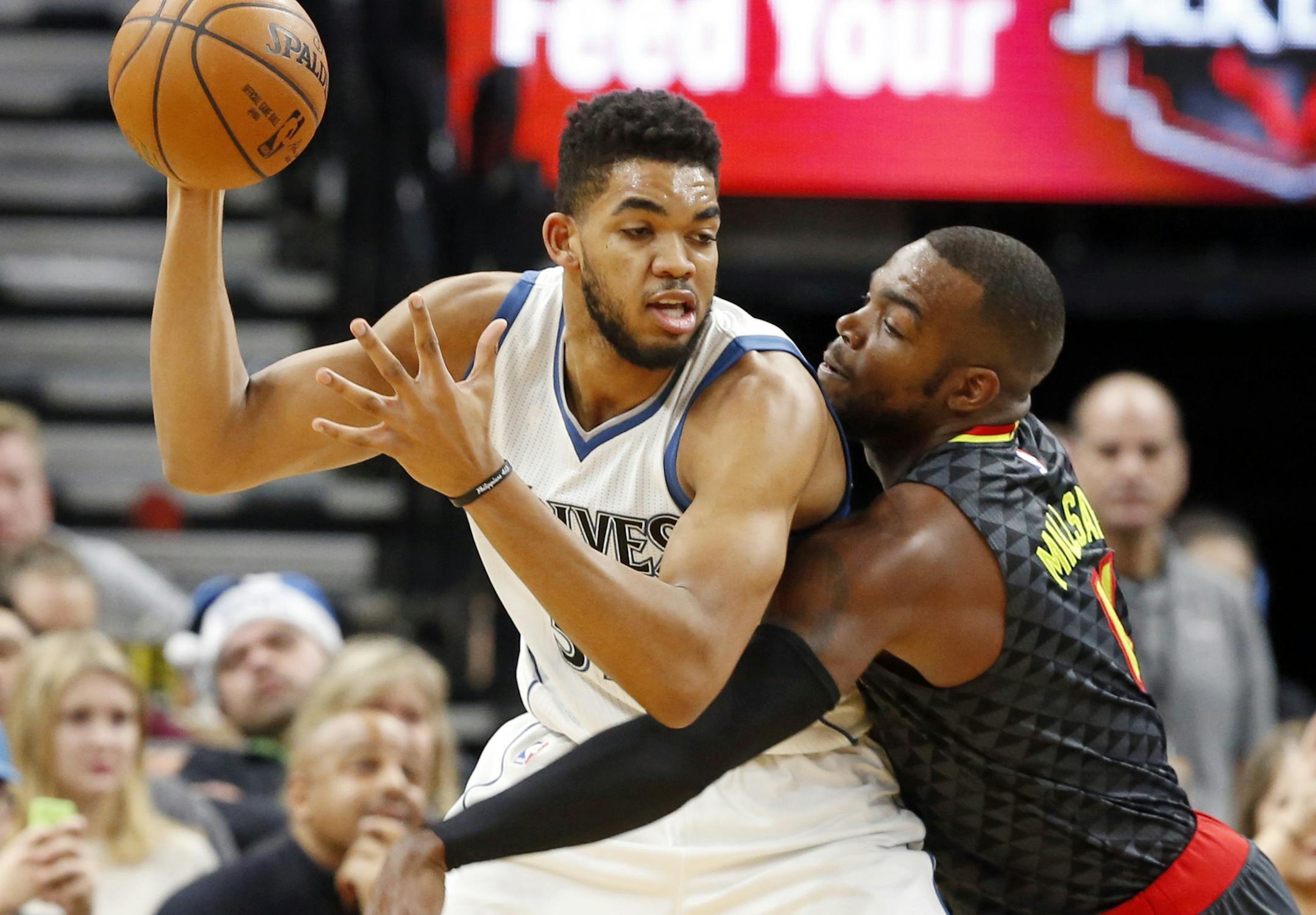 Minnesota Timberwolves' Karl-Anthony Towns, left, keeps the ball at bay from Atlanta Hawks' Paul Millsap during the first half of an NBA basketball game Monday, Dec. 26, 2016, in Minneapolis. (AP Photo/Jim Mone)