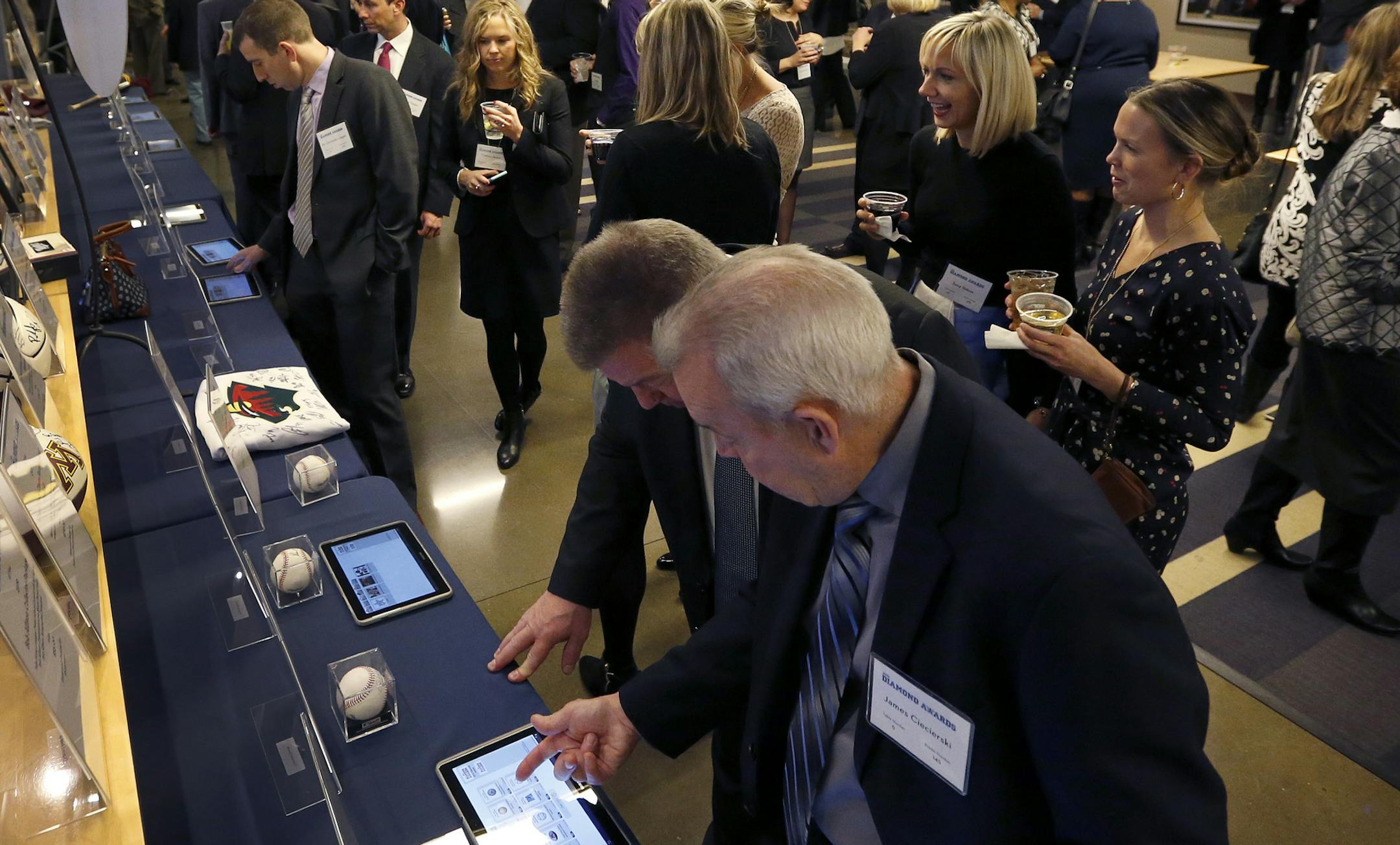 Attendees looked over items in the silent auction at the Diamond Awards held at Target Field on Thursday night. ] CARLOS GONZALEZ cgonzalez@startribune.com - January 28, 2016, Minneapolis, MN, Target Field, MLB, Minnesota Twins, Diamond Awards