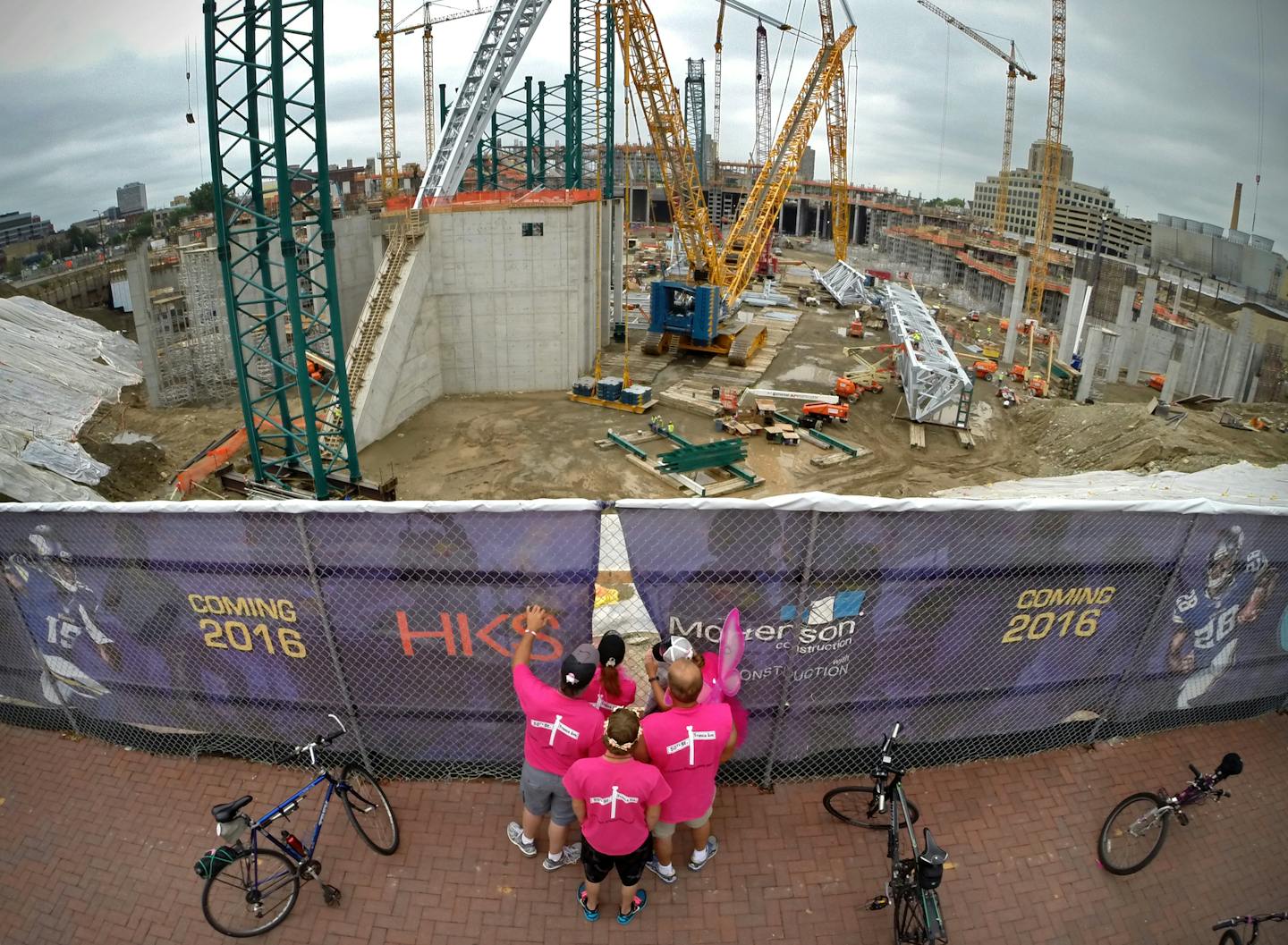 The third-party operator is named for the new $1 billion Minnesota Multipurpose Stadium. Here, folks take a break from the Susan G. Komen 3-Day event to peek through the gaps in the fencing outside the stadium construction site, trying to get a glimpse of the massive project. ] BRIAN PETERSON &#x201a;&#xc4;&#xa2; brian.peterson@startribune.com Minneapolis, MN 08/22/14 ORG XMIT: MIN1408221541338773