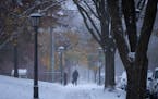 A pedestrian walks down a St. Paul street during the first snow of the winter in October of last year.