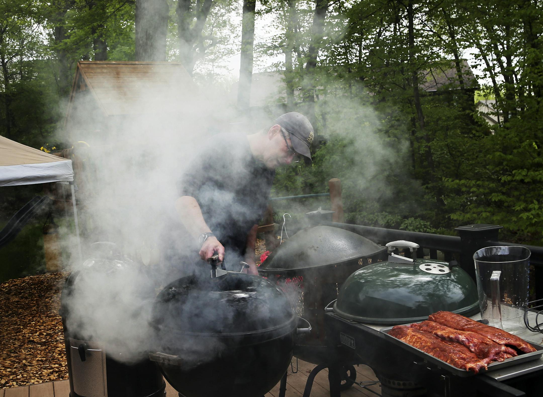 Pat McTigue replaces the lid on a smoker after putting a whole turkey on during Smokapalooza 2013, on the deck of the Pupel family residence Saturday, May 26, 2013 in Plymouth, MN.](DAVID JOLES/STARTRIBUNE) djoles@startribune How do you learn the intricacies and nuances of user a smoker? By having lots and lots of experiments going on at one time. How do you do that? By gathering 10 families, smokers and grills at the ready, for Smokapalooza. Everyone learns, by successes and failures, and they