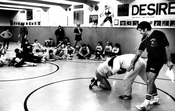 Coach Dave Arens worked with Bloomington Kennedy wrestlers in 1980.