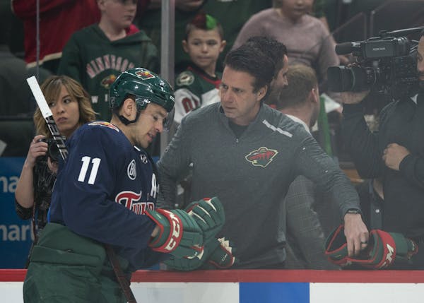 The Wild's Head Equipment Manager Tony Dacosta swapped out a pair of gloves with left wing Zach Parise (11) during pregame warmups Tuesday night. ] JE
