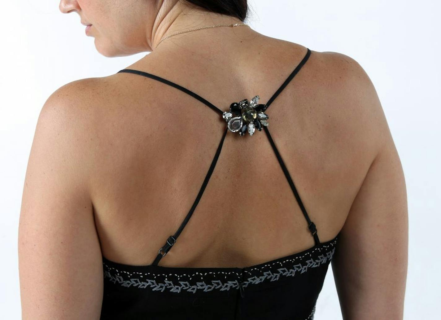 An easy and whimsical way to shorten spaghetti straps that are too loose is to use a brooch.