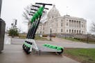 Lime scooters are lined up across the street from the Minnesota State Capitol in St. Paul. The scooters will now be available for pickup at Minneapoli