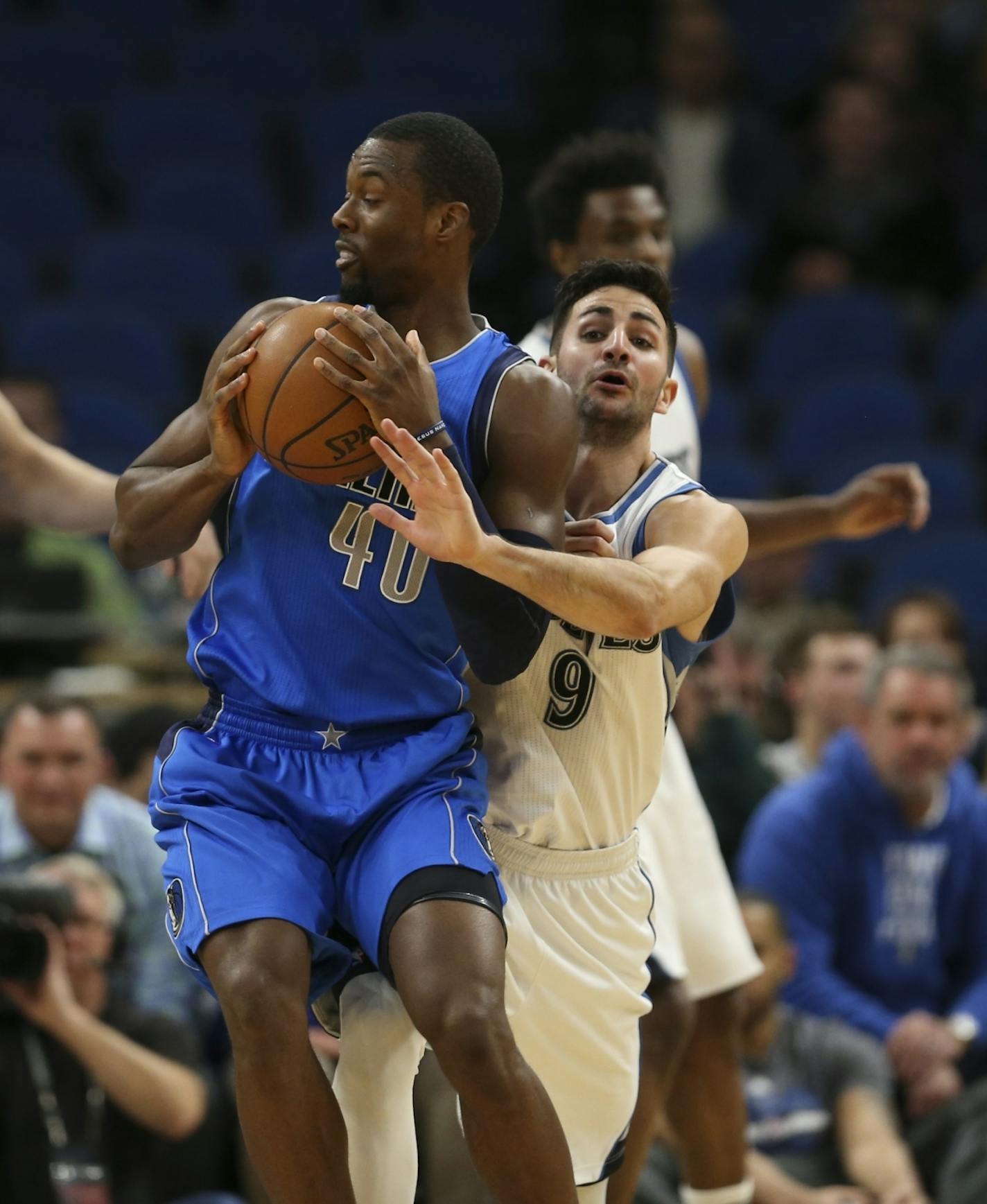 Minnesota Timberwolves guard Ricky Rubio (9) reached around Dallas Mavericks forward Harrison Barnes (40) while guarding him in the first quarter.