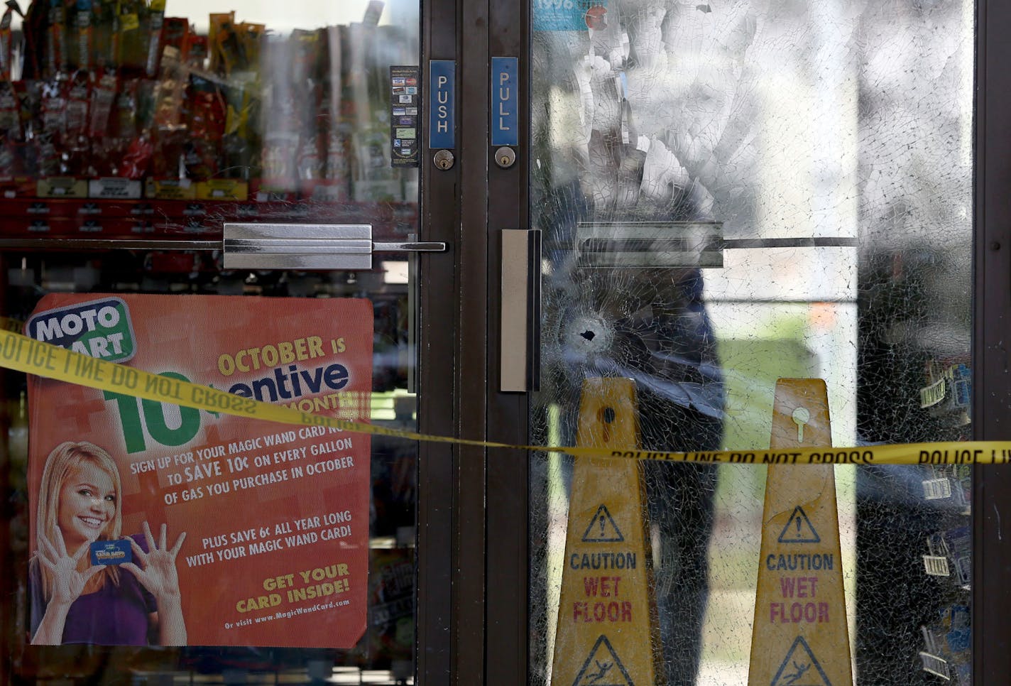 What appeared to be a bullet hole in the glass door at the Moto Mart on Hiawatha Ave and 33rd Street. ] (KYNDELL HARKNESS/STAR TRIBUNE) kyndell.harkness@startribune.com At Moto Mart in Minneapolis Min., Tuesday, September 23, 2014. Three people were in the hospital after they were shot early Tuesday at a south Minneapolis gas station