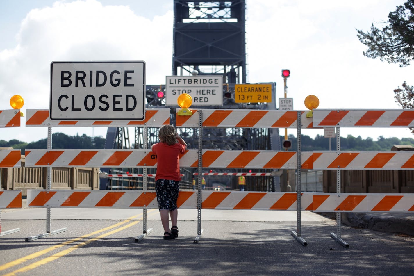 Maddox Feiner, 8, watches the Minnesota Department of Transportation close the Stillwater bridge on Monday morning due to high water on the St. Croix river.