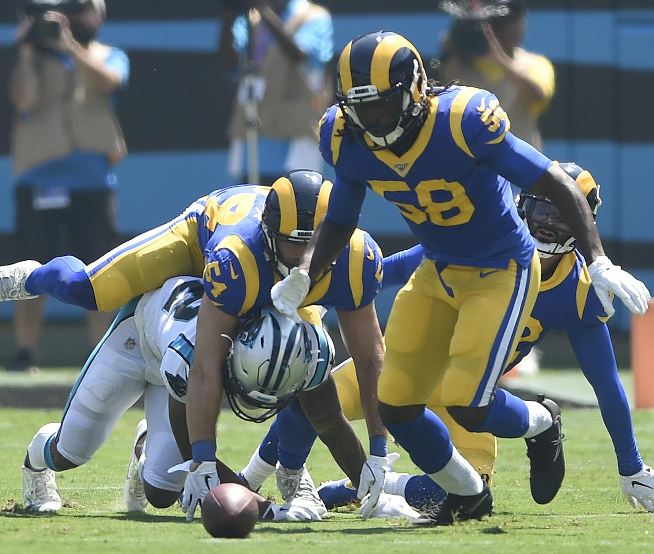 Carolina Panthers wide receiver D.J. Moore fumbles while Los Angeles Rams inside linebacker Cory Littleton (58) and linebacker Bryce Hager (54) scramble to recover during the first half in Charlotte, N.C.