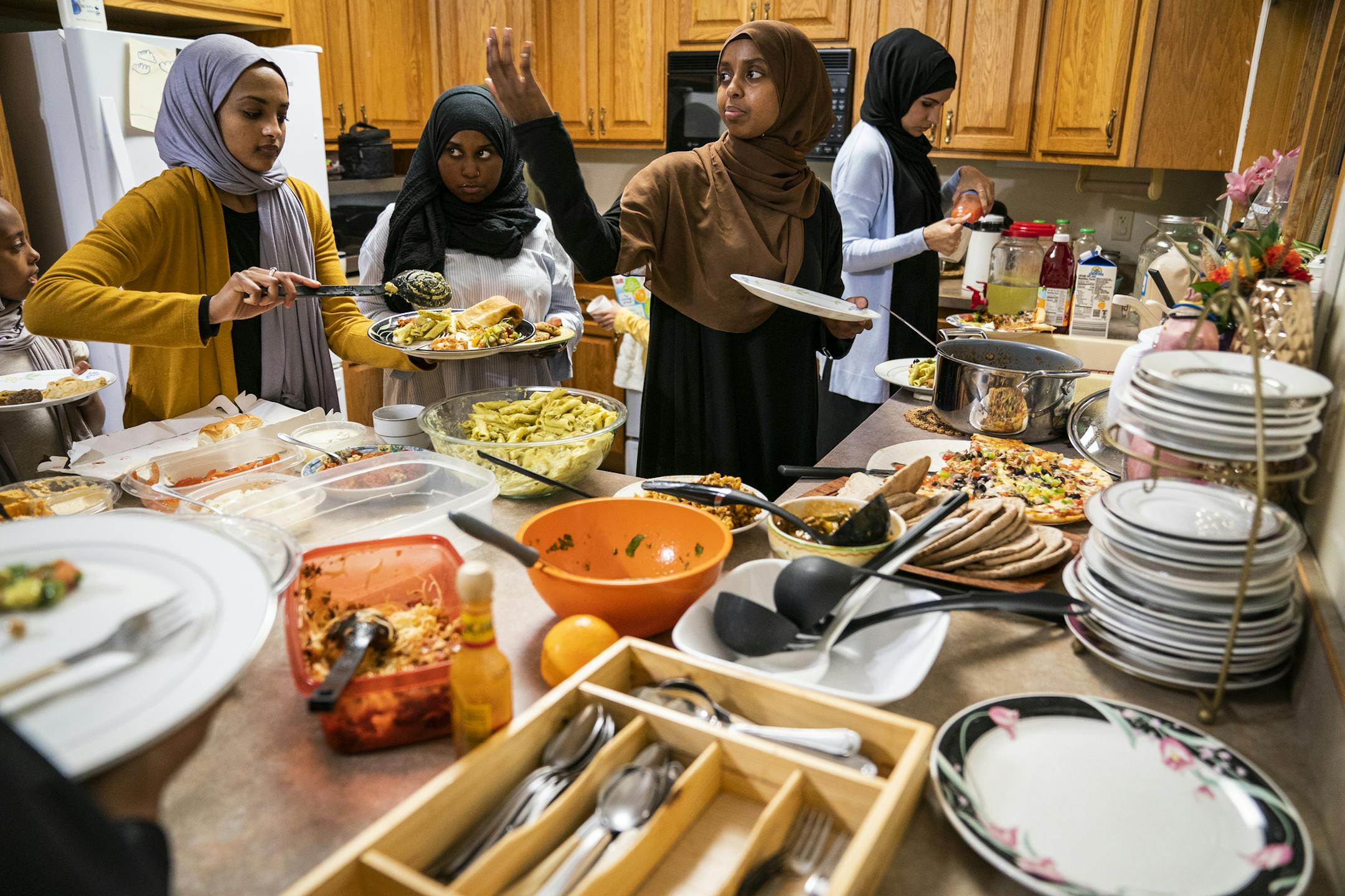 Women serves themselves with real plates and utensils during the potluck Iftar dinner at Club ICM. ] LEILA NAVIDI ¥ leila.navidi@startribune.com BACKGROUND INFORMATION: Iftar potluck dinner during Ramadan at Club ICM in Fridley on Tuesday, May 14, 2019. For a story on initiatives taken by different Muslim organizations to ensure minimum wastage of food and minimal trash waste during Ramadan and Iftar get togethers.