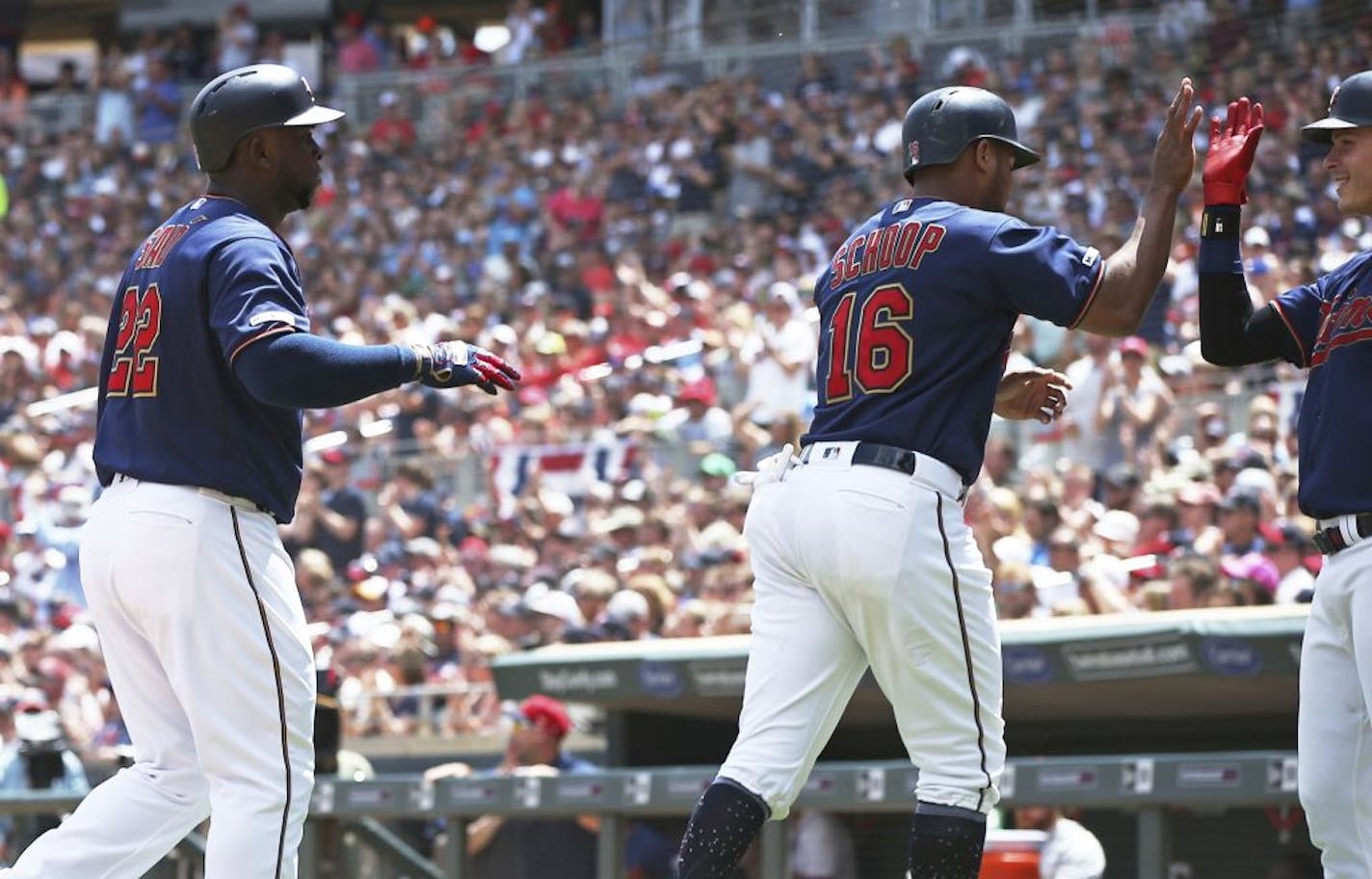 Minnesota Twins' Max Kepler, right, greets Jonathan Schoop and Miguel Sano, left, after they scored on a Byron Buxton single off Texas Rangers pitcher Jesse Chavez in the second inning of a baseball game Saturday, July 6, 2019, in Minneapolis.