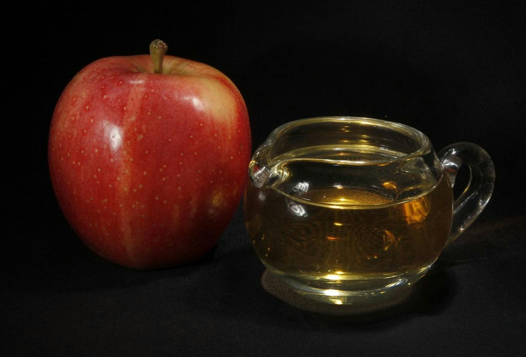 FILE - In this Sept. 15, 2011 photo, an apple and a pitcher of apple juice are posed together in Moreland Hills, Ohio. Despite the government's consideration of new arsenic limits on the juice, the real danger, nutrition experts say, is to waistlines and teeth. Apple juice and other juice-based beverages have relatively few natural nutrients, many calories and more sugar, in many cases, than a can of soda.