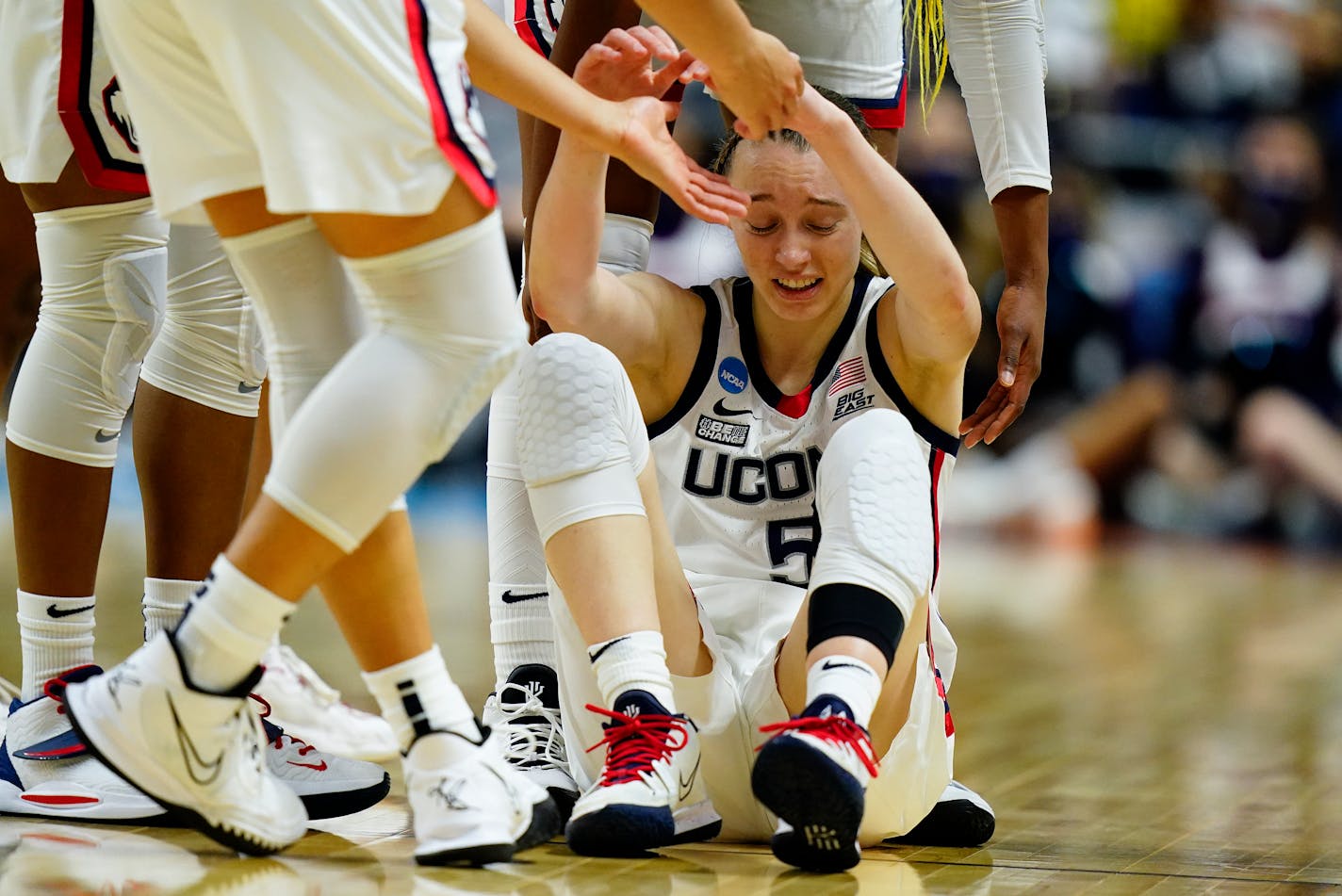 Connecticut guard Paige Bueckers (5) is helped up off the court during the first quarter of a college basketball game against Indiana in the Sweet Sixteen round of the NCAA women's tournament, Saturday, March 26, 2022, in Bridgeport, Conn. (AP Photo/Frank Franklin II)