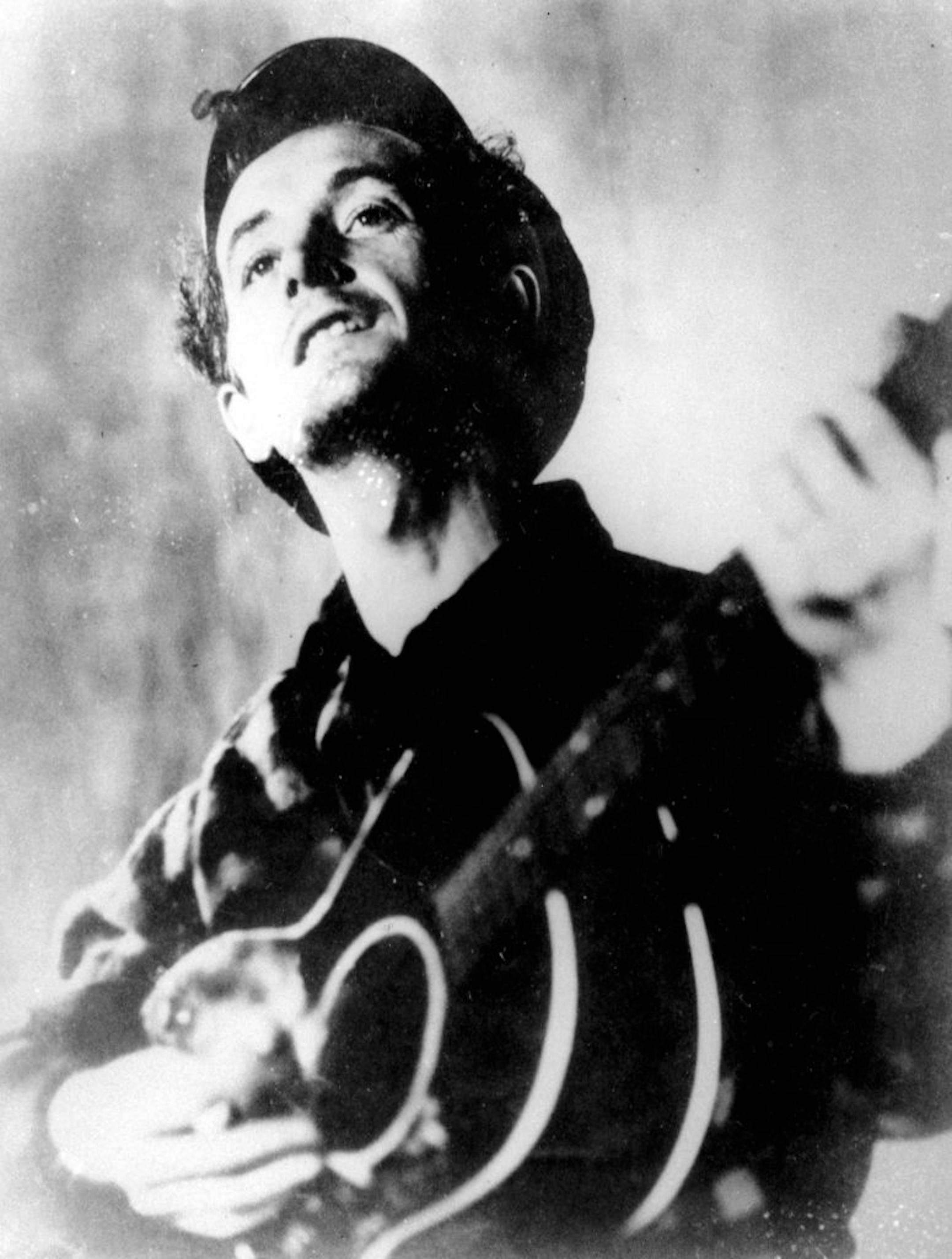 This is an undated photograph of folk singer Woody Guthrie playing his guitar. (AP Photo) ?